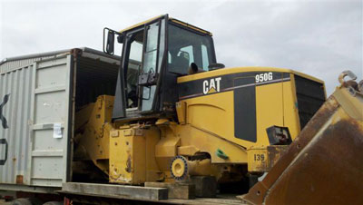 Caterpiller 950 wheel loader is loaded onto cube container for international transport by Export Logistics & Shipping, Inc.